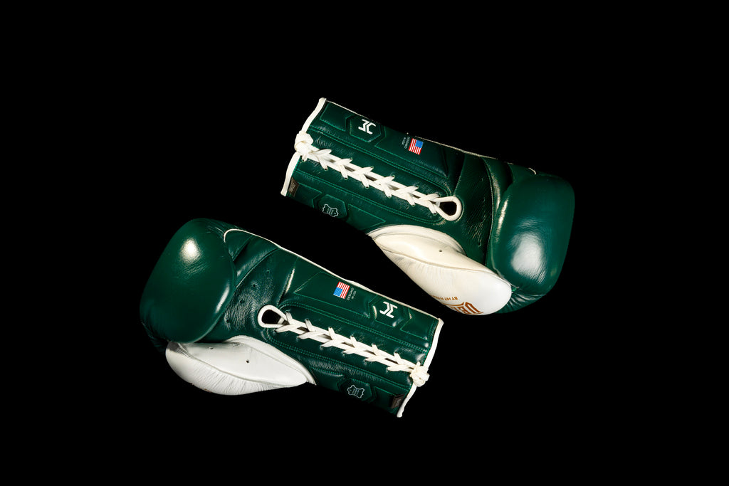Green and white HIT'N'MOVE VECTOR boxing gloves on a black background, showing white laces and palm sides