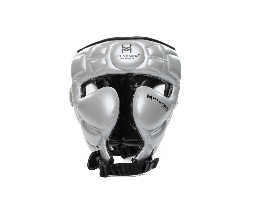 Silver HIT'N'MOVE Air Armor Precision boxing headgear with black logos, cheek padding and black chin strap, front view